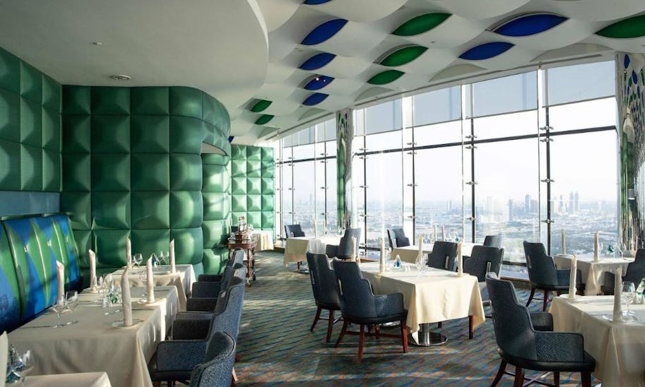 A luxurious looking dining room in a skyscraper looking out over Dubai