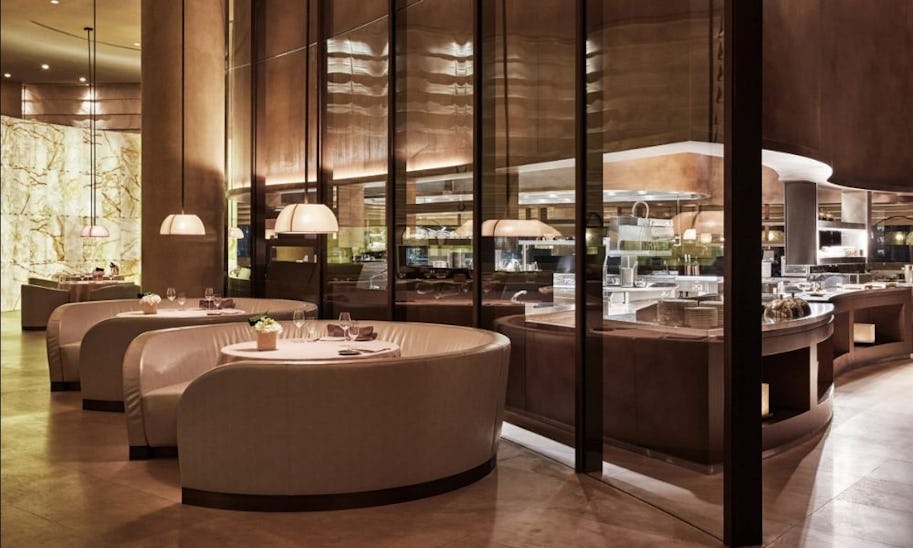 A well designed dining room with curved banquette seats and low-hanging lights