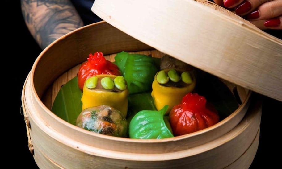A basket of steamed dim sum in colourful wrappers