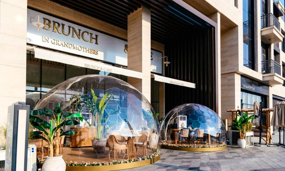 Two clear dining domes with small tables set up in them